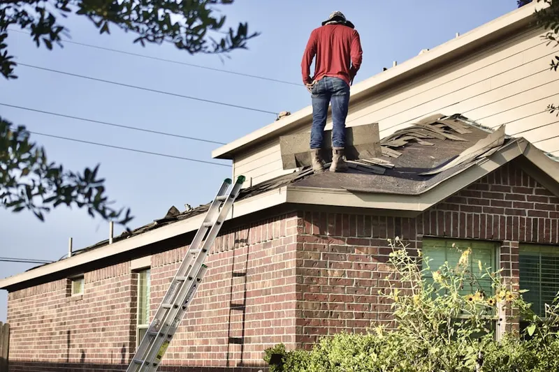Professional roofer working on a residential roof in Prospect Park - East River Road